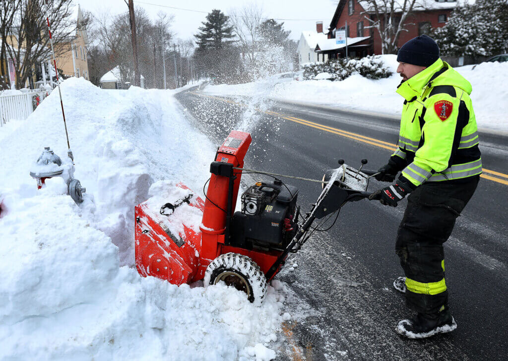 Firefighter Paul Arman clears fire hydrants on Elm Street.