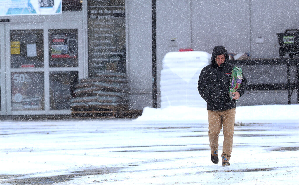 A customer exits Rocky's Ace Hardware with supplies as snow falls Monday. Photo: Ken McGagh/The Acton Bridge