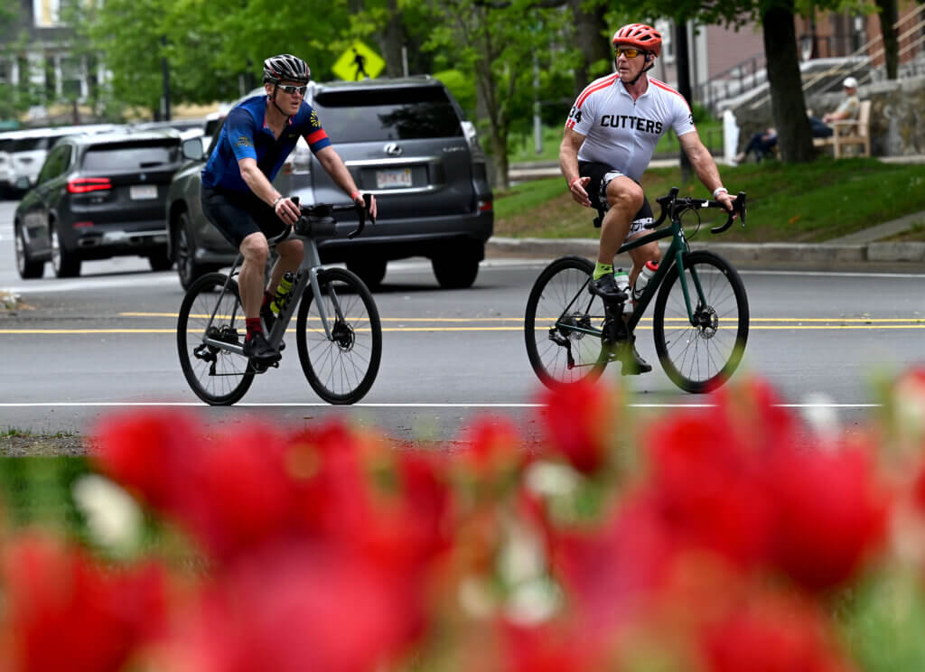 Cyclists pass flowers at the First Parish Church.