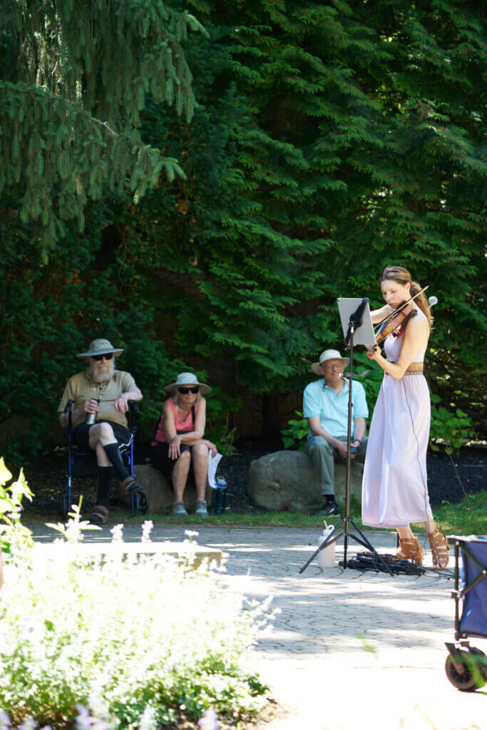 _DSC0854 Sarah Whitney, Acton resident, plays violin in the CCM Labyrinth. Robert VanDyck (Acton resident) looks on from directly behind. (The other two people are not Acton residents) Photo by Edward Feather
