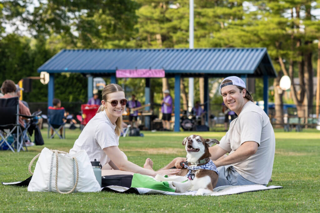 Lea Murphy, left, and Ryan Murphy with Daphne, a husky/Lab mix, take in their first Rideout concert after moving here from New York City. “Love it,” they say. Photo: Stephen Beyer/The Acton Bridge