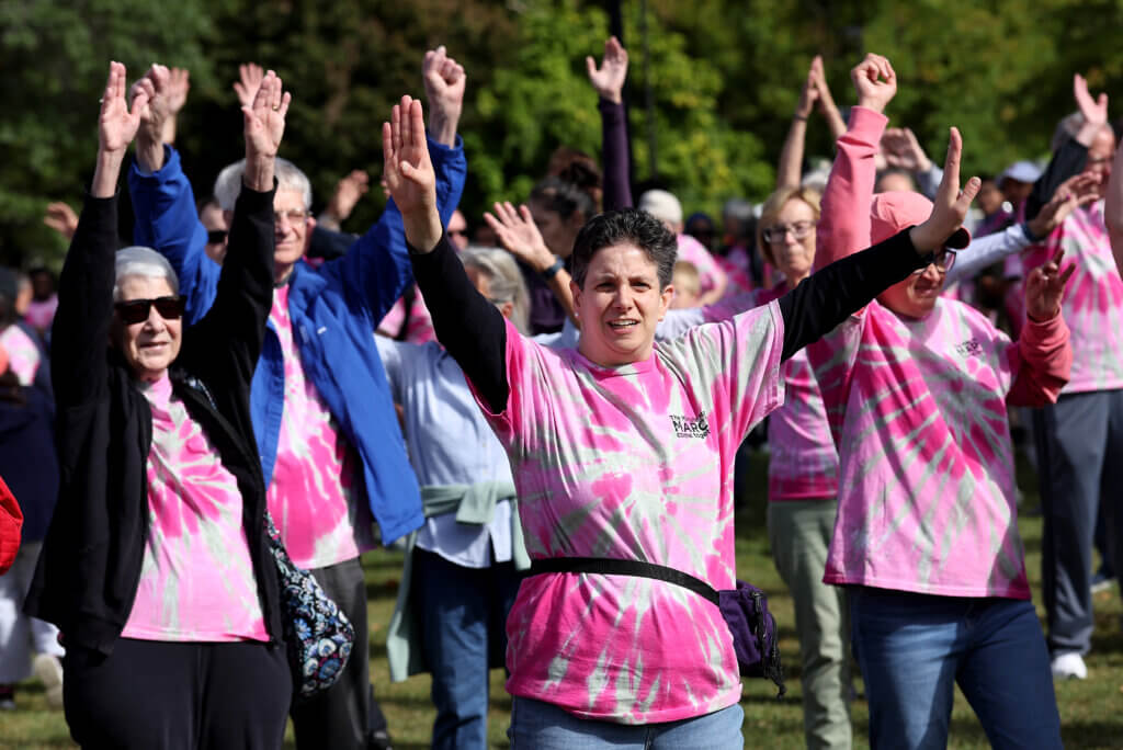 Stephanie Palm of Acton, center, and others take part in a group exercise before the Minute Man Arc’s 22nd annual Minute Man March on Saturday, September 19, 2026. The event raises funds and awareness the nonprofit’s programs supporting over 1,400 adults and children with disabilities in Middlesex County. Ken McGagh/The Acton Bridge