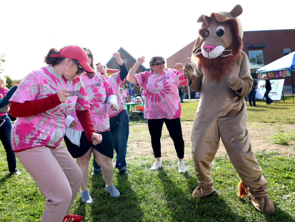 Kim Harney, left, and others dance with a lion before participating in the Minute Man Arc’s 22nd annual Minute Man March on Saturday, September 19, 2026. The event raises funds and awareness the nonprofit’s programs supporting over 1,400 adults and children with disabilities in Middlesex County. Ken McGagh/The Acton Bridge