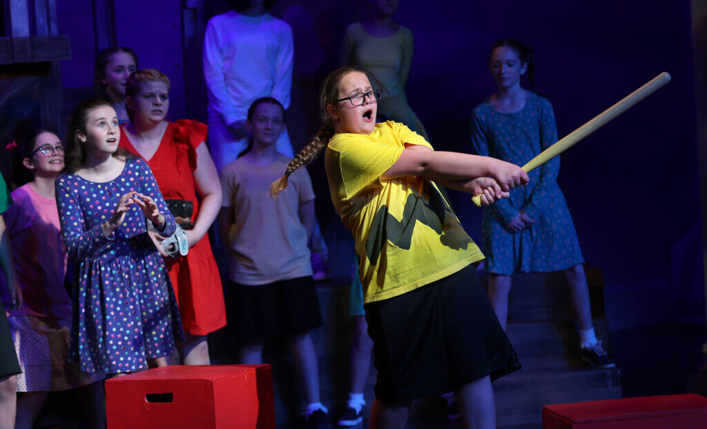Charlie Brown, (Stella DuBray) takes a swing during the Baseball Game scene from “You’re A Good Man Charlie Brown” in West Acton on Thursday, July 23, 2026. Ken McGagh/The Acton Bridge