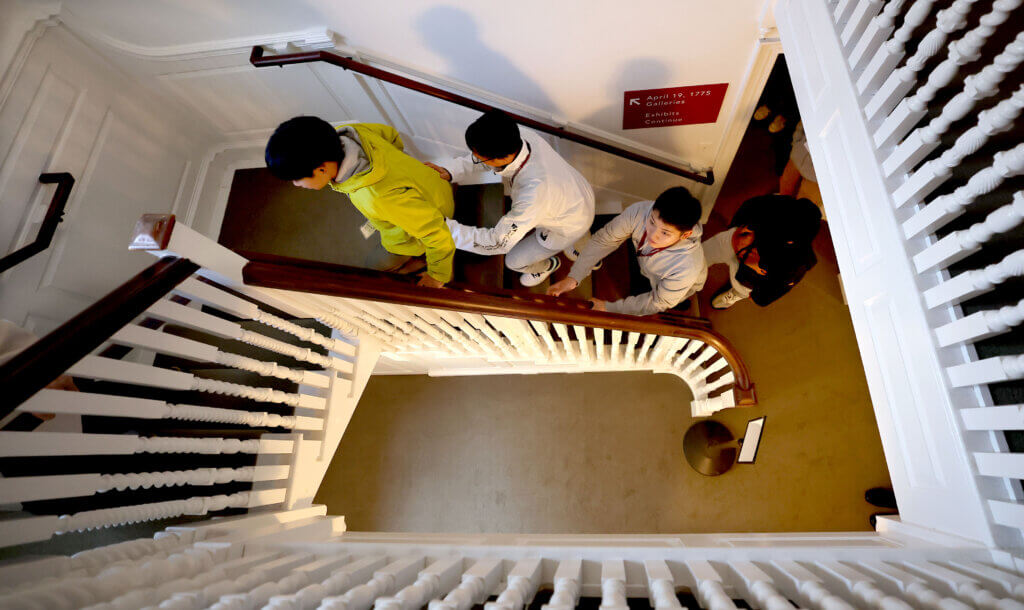 Nanae students Outa Kitamura, left, Joshin Kugita and Shogo Kimura ascend a staircase during a visit to the Acton Museum on Tuesday, October 28, 2025. Ken McGagh/The Acton Bridge