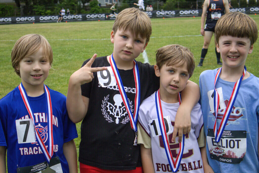 From left: Julian Disciscio, Riley Nurse, Roger Pavlik, and Elliott Lane, all 8-year-olds attending Alcott Elementary, show off their medals after the race. Photo by Emma Green