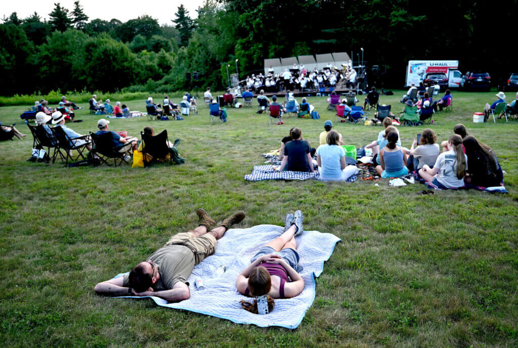 Concertgoers relax on the lawn as they tune in to the band, whose musicians hail from more than 40 communities, including Acton. Photo: Ken McGagh/The Acton Bridge