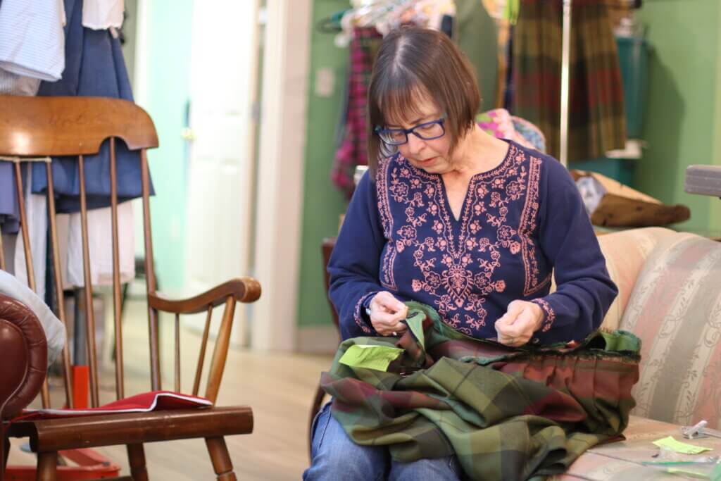 Tina Zanieri stitches on one of the many kilts needed for the production. Photo: Trace Salzbrenner/The Acton Bridge