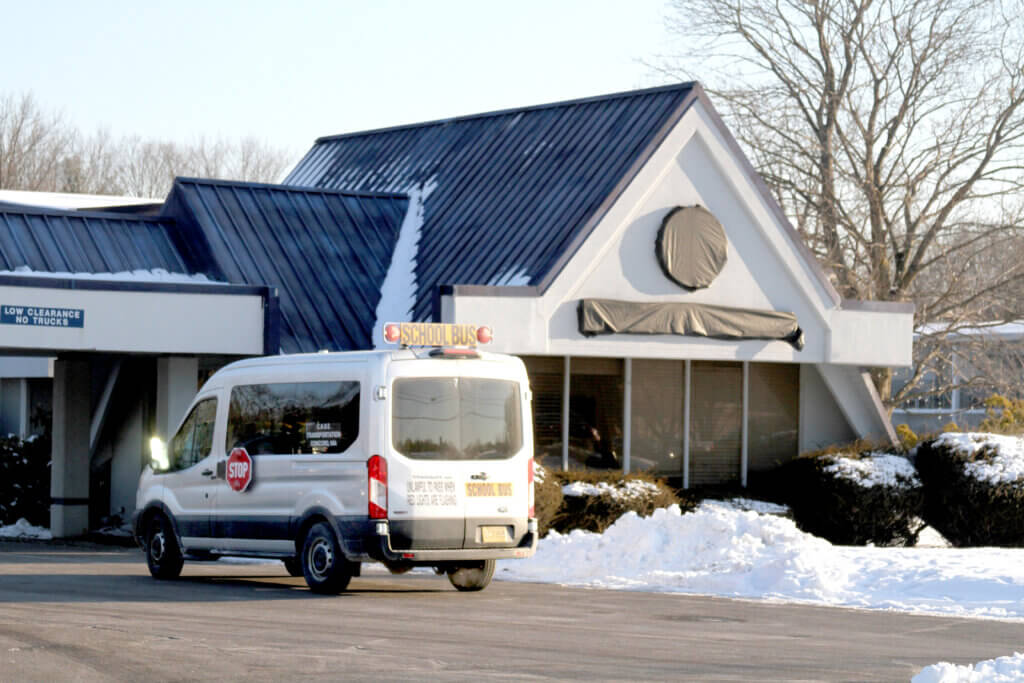 A van waits to pick up students from the Elm Street shelter. Though the state reimburses schools, out-of-district transportation costs are in focus as local leaders prepare the 2025-2026 school budget. Photo: Dakota Antelman/The Acton Bridge