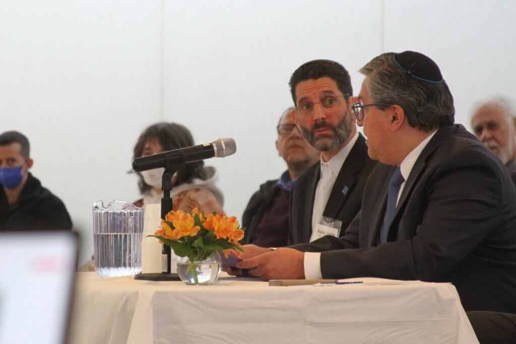 Rabbi Darby Leigh looks on as Rabbi Braham David from Congregation Beth Elohim in Acton speaks. Photo: Dakota Antelman/The Acton Bridge