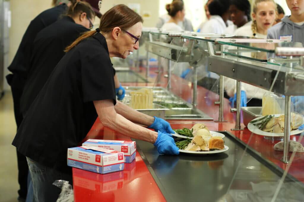 Cafeteria worker Toni Small hands off plates with all the fixings. Photo: Trace Salzbrenner/ The Acton Bridge