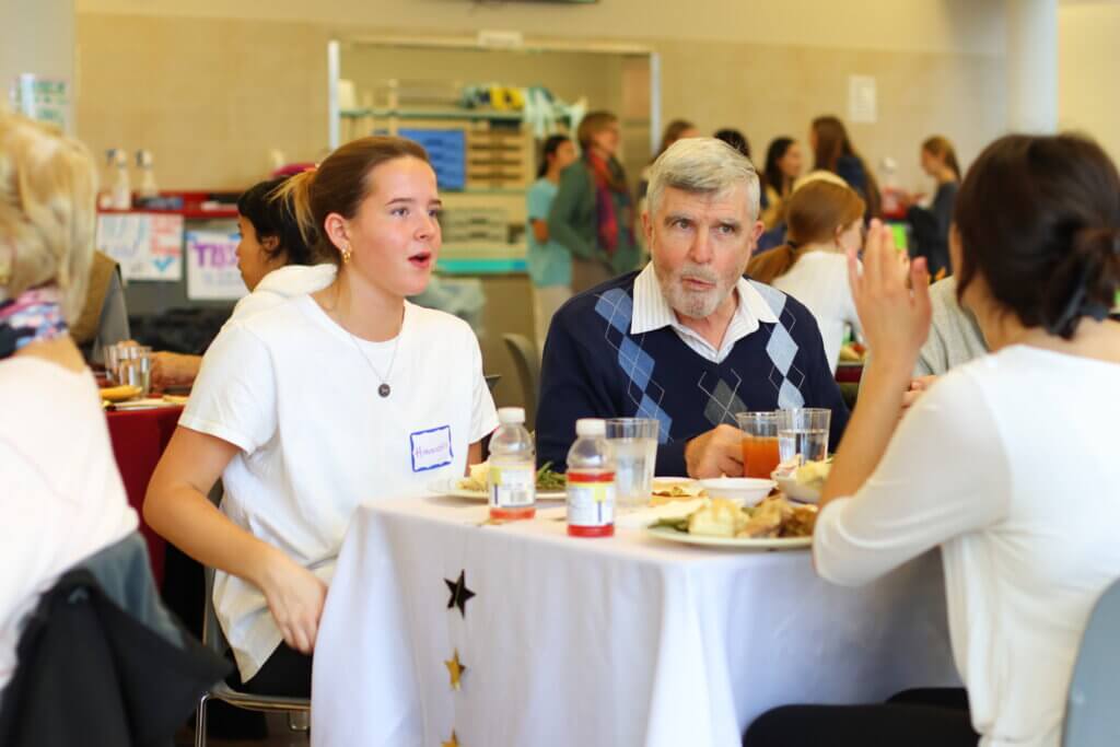 Hannah Cohen and Patrick Dreher listen to a story. CCHS students not only served, but sat down to lunch with guests. Photo: Trace Salzbrenner/ The Acton Bridge