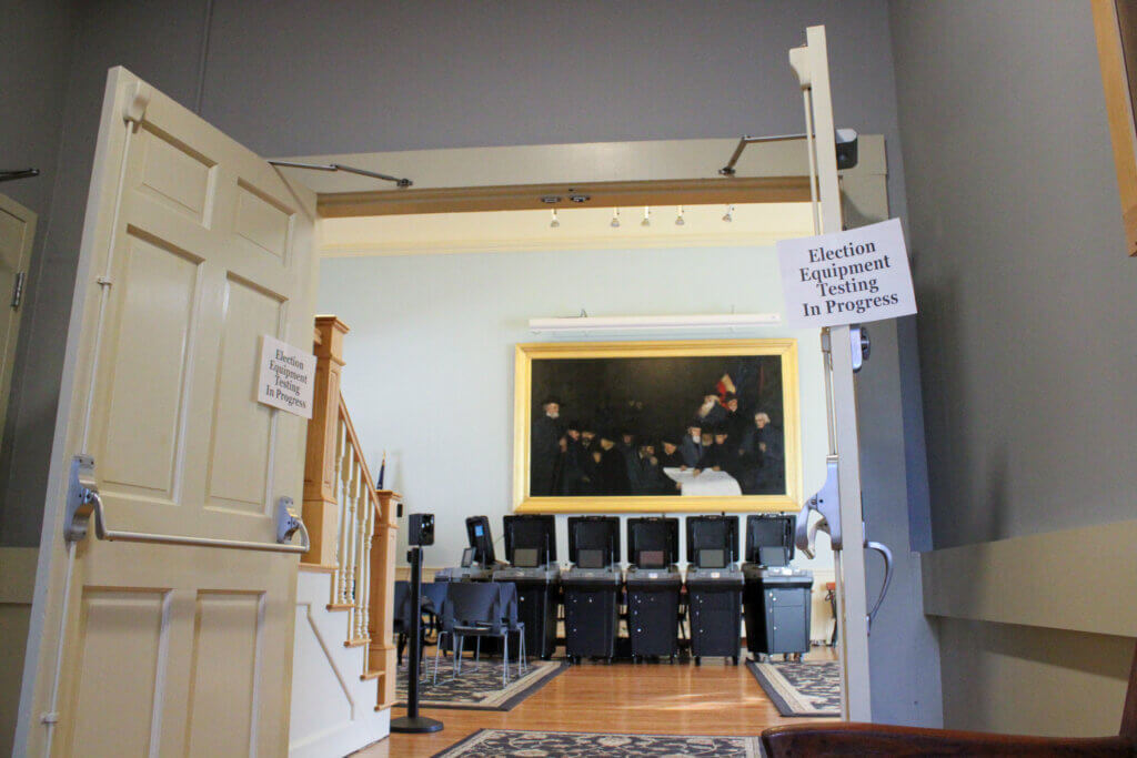 Signs marked the entrance to the Town House hearing room ahead of election machine testing. Photo: Dakota Antelman/The Acton Bridge