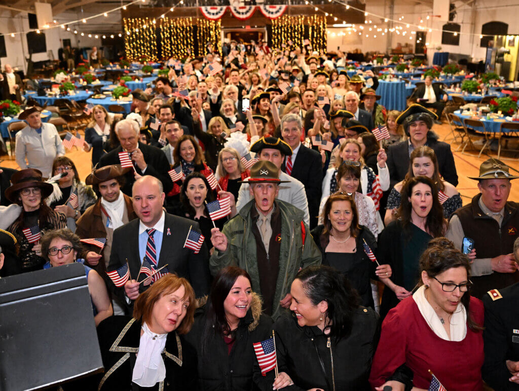 Attendees sing “God Bless America” after the Grand March Promenade at the conclusion of the 2025 Patriots’ Ball at the Acton Armory on Saturday, April 12, 2025. Ken McGagh/The Acton Bridge