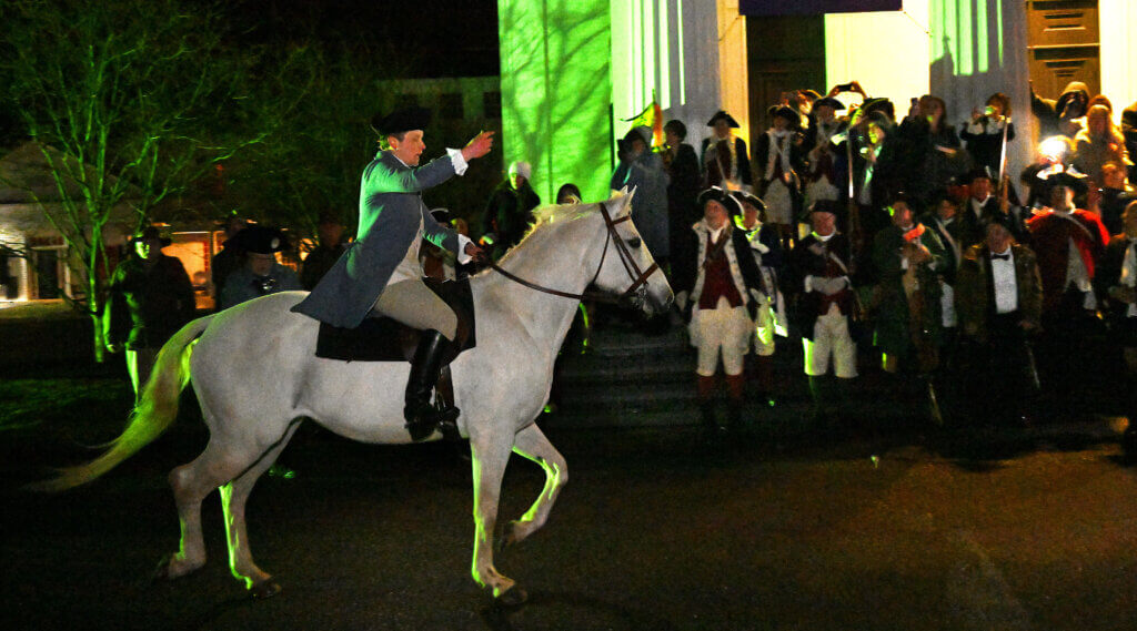 Georgia Barry of the Acton Minutemen, re-enacting Dr. Samuel Prescott’s ride to warn of the advancing Britiish troops on the night of April 18, 1775, reaches the First Parish in Acton after the 2025 Patriots’ Ball at the Acton Armory on Saturday, April 12, 2025. Ken McGagh/The Acton Bridge