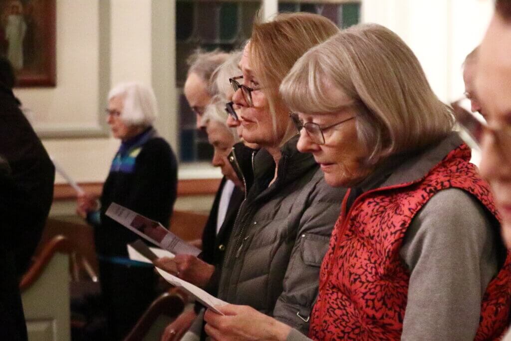 Sue Tunnicliffe and Diane Hannon sing “Courage, My Friend” with the crowd. The song originates from the South African anti-apartheid movement. Photo: Trace Salzbrenner/The Acton Bridge
