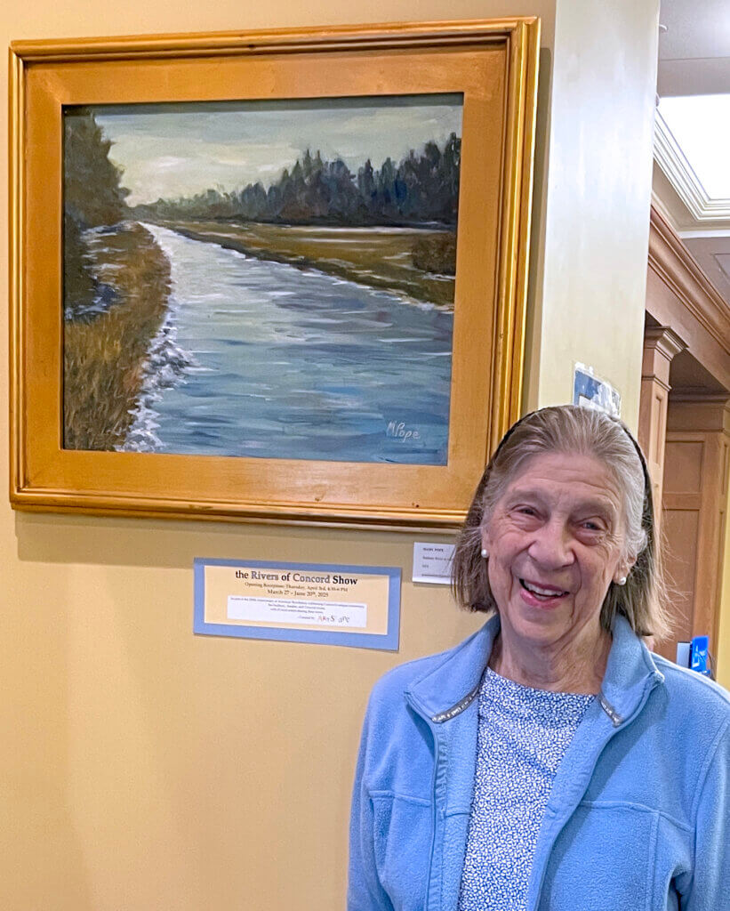 Acton’s Mary Pope at the Fowler Library with her painting ”Sudbury River in Winter at Heath's Bridge, Acton.” Courtesy photo