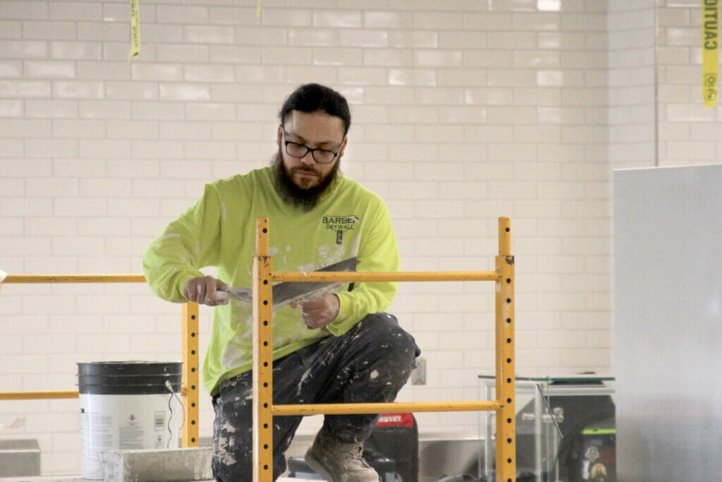A project worker helps put the finishing touches on the kitchen area. 