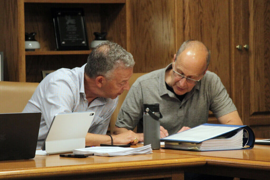 MCI-Acton Advisory Board member John Boynton, left, and panel co-Chair Dan Gainsboro review a document. Photo: Dakota Antelman/The Acton Bridge