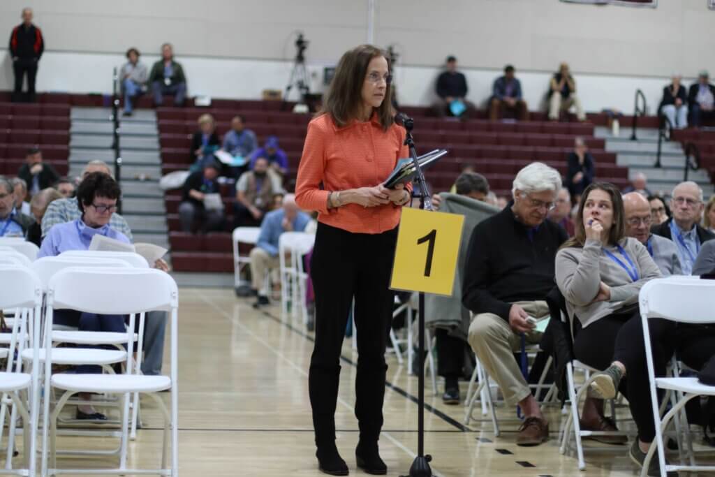 Voter Gail Hire speaks from the floor in the Acton-Carlisle High School gym on the second night of Town Meeting 2026. Photo: Trace Salzbrenner/The Acton Bridge