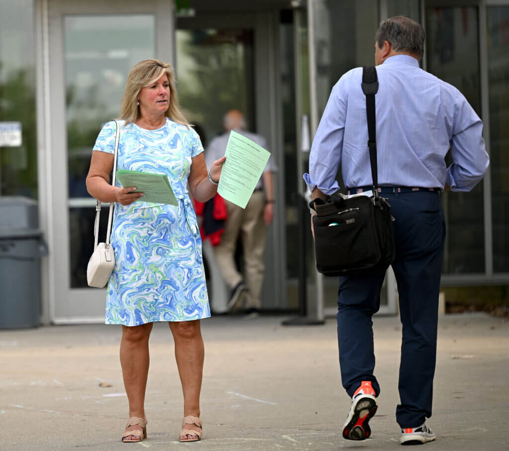 Carol Savoy hands out flyers urging residents to vote NO on Article 44 (Zoning Bylaw Amendment). Photo: Ken McGagh/The Acton Bridge