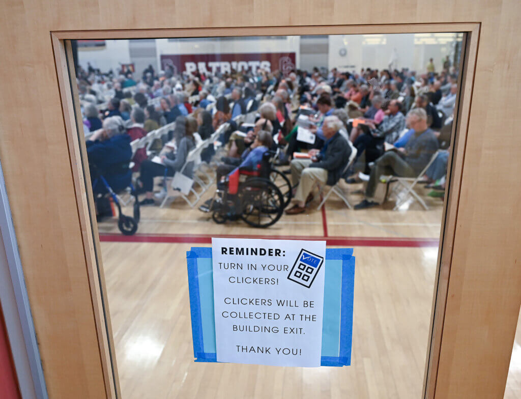 A sign at Acton-Carlisle High School reminds Town Meeting voters to turn in their clickers. Photo: Ken McGagh/The Acton Bridge