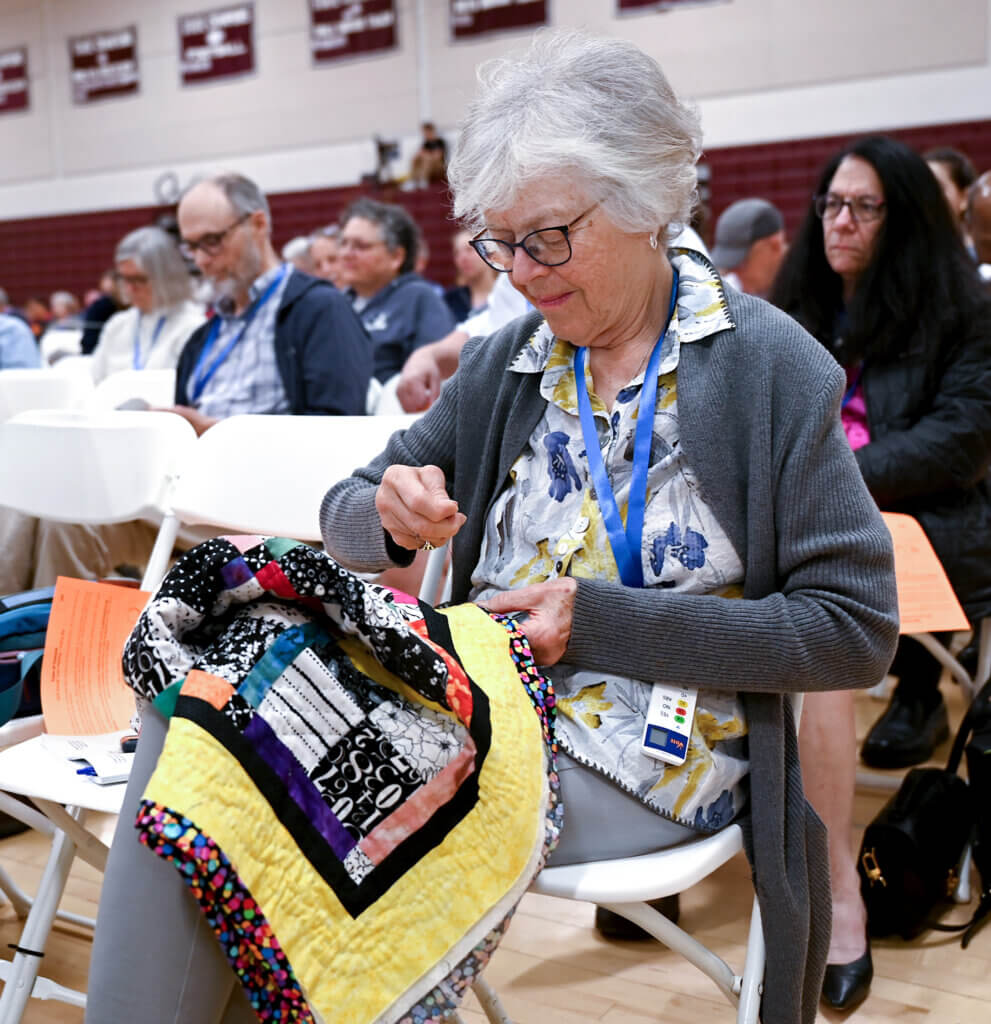 Alice Van Deusen works on a quilt while attending Town Meeting. Photo: Ken McGagh/The Acton Bridge