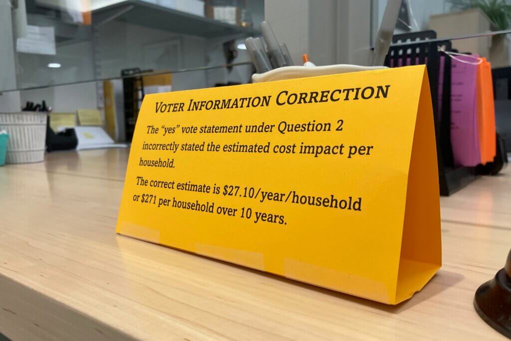 A sign disclosing an error on a townwide voter information mailer greeted visitors to the Town Clerk’s Office this summer. Photo: Dakota Antelman/The Acton Bridge