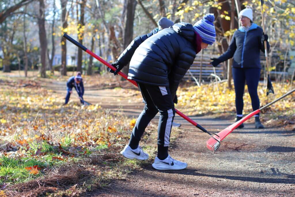 Thomas Hoffman diligently tries to get small bits of debris out of the Reformatory Branch Trail only a dozen feet away from Lowell Road. Photo: Trace Salzbrenner/The Acton Bridge