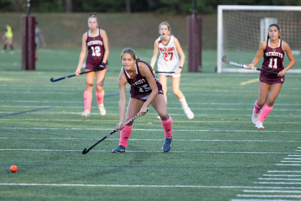 Skyla Rigazio, co-captain Kaia Triola, and Zoë Bonzagni defend their home turf against the Wayland Warriors. Photo by David Clancy