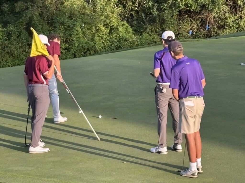 Joe Grasso drops one in on the ninth hole as teammate Fisher Tibbitt tends to the flag. Photo by Carl Sweeney