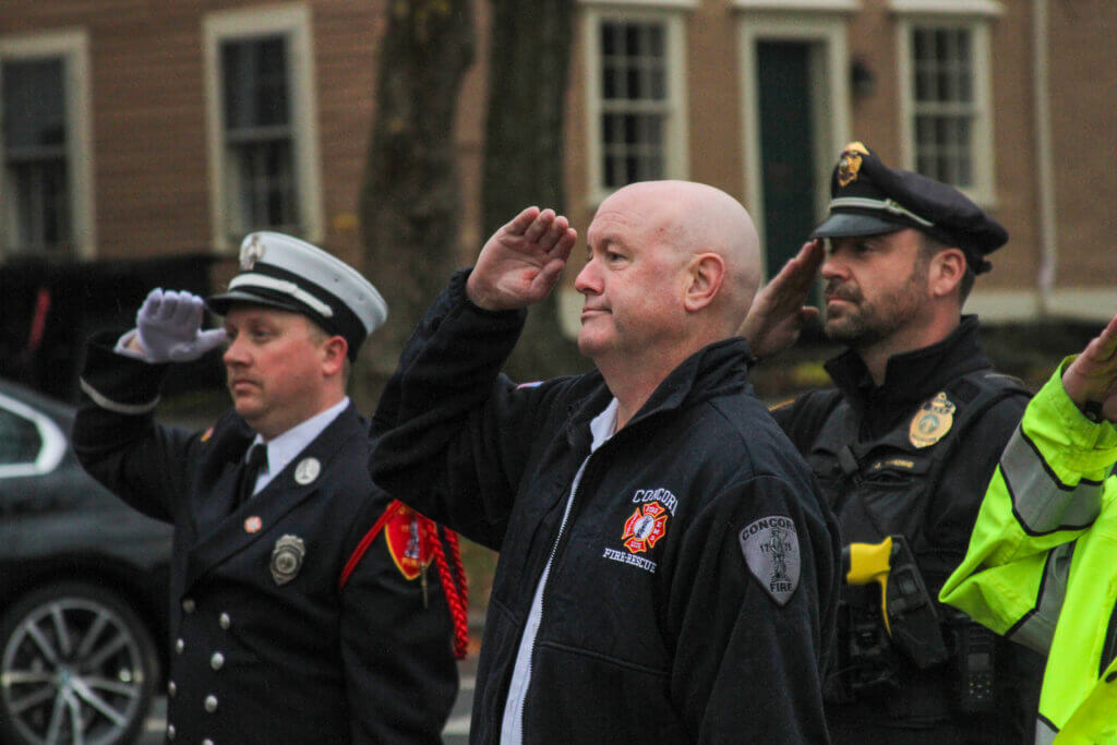 Fire Chief Brian Whitney salutes during a ceremonial raising of the Marine Corps flag.