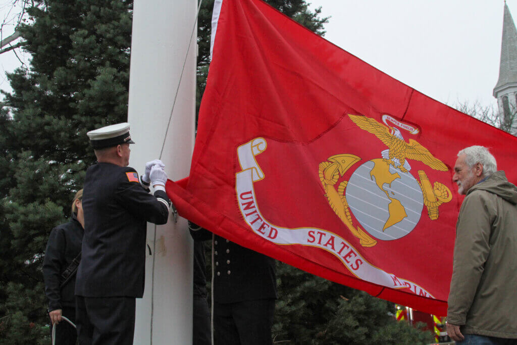 Sean Murphy, left, and fellow Marine veterans Leo Carroll, right, and Bob Recco, not pictured, helped raise the Marine Corps banner.