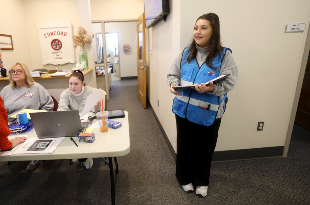 Timalyn Rassias, left, office coordinator for the Acton Fire Department, Kimberly Lombardo, Acton Public Health Office coordinator, center, and Lindsey Denney, right, of Acton human resources, register community members volunteering to be shelter-seekers. Photo: Ken McGagh/The Acton Bridge