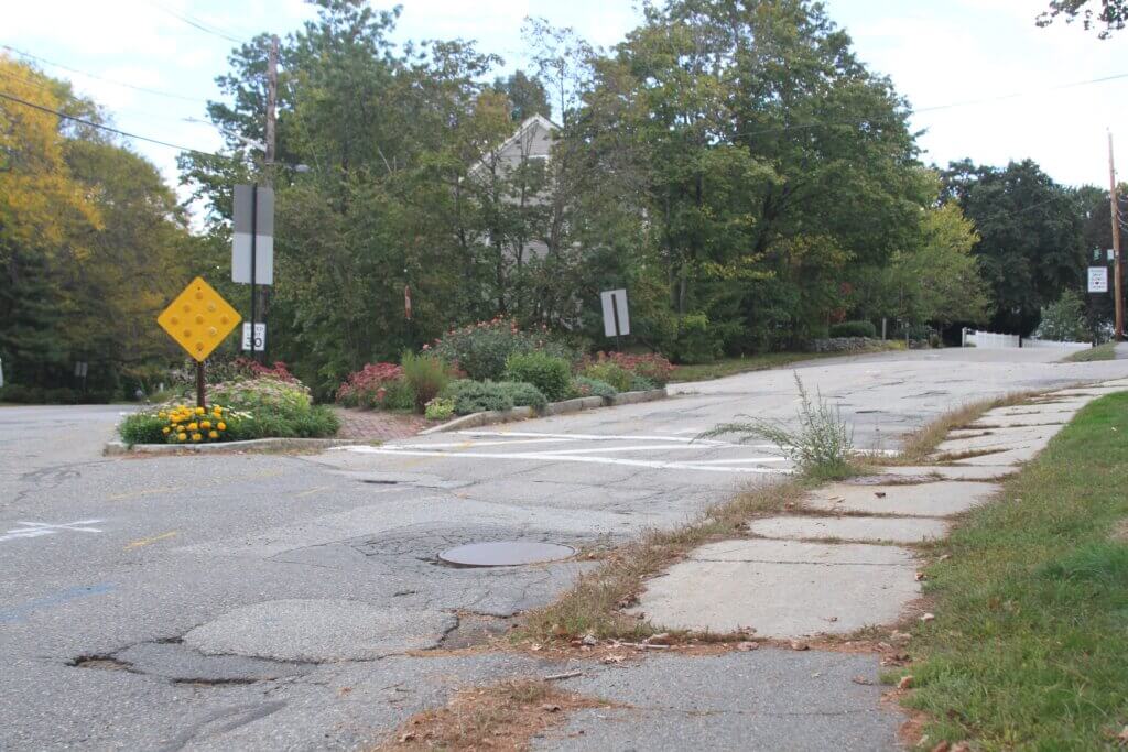A planned roadway redesign would eliminate a hazardous “slip lane” next to a West Acton Green Thumbs flower bed on Old Bridge Road. Photo: Dakota Antelman/The Acton Bridge
