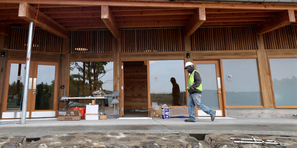 A construction worker walks by the bathhouse’s men’s room at Walden Pond on Wednesday, May 13, 2026. Ken McGagh/The Acton Bridge