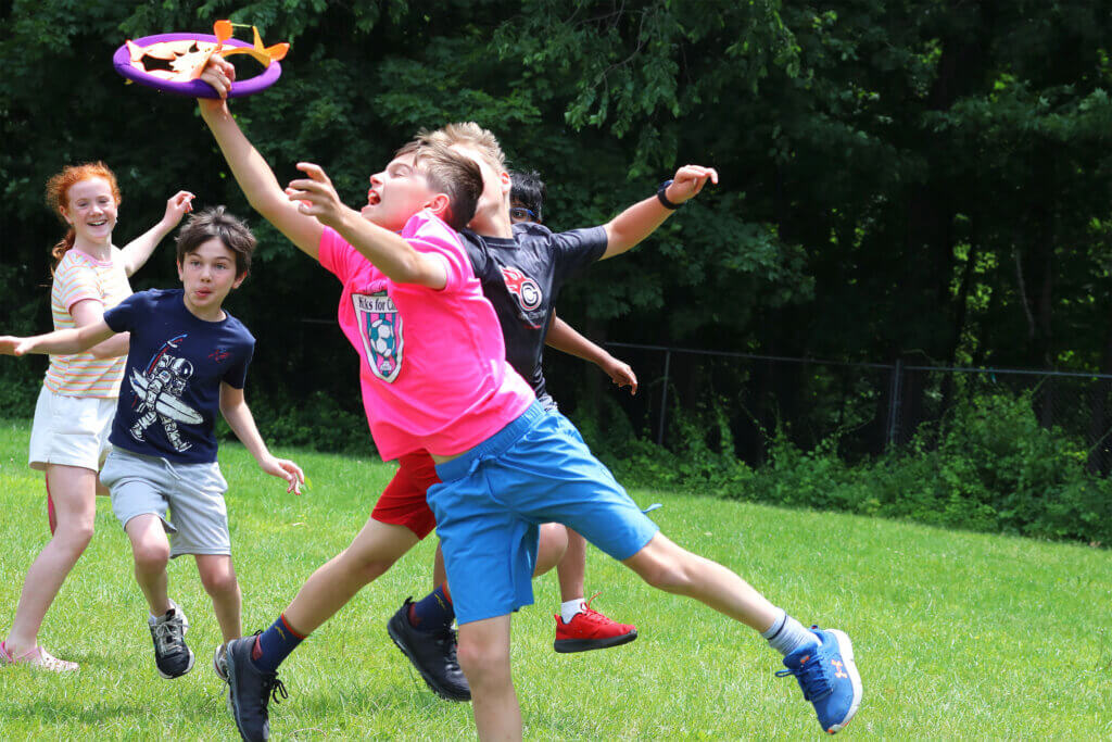 Kids from the Student Playground Leadership Team play with an old Frisbee on the site of the new playground. Photo: Trace Salzbrenner/The Acton Bridge